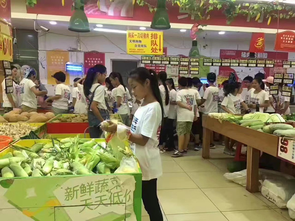 孩子们认真的在选择自己想要买的蔬菜